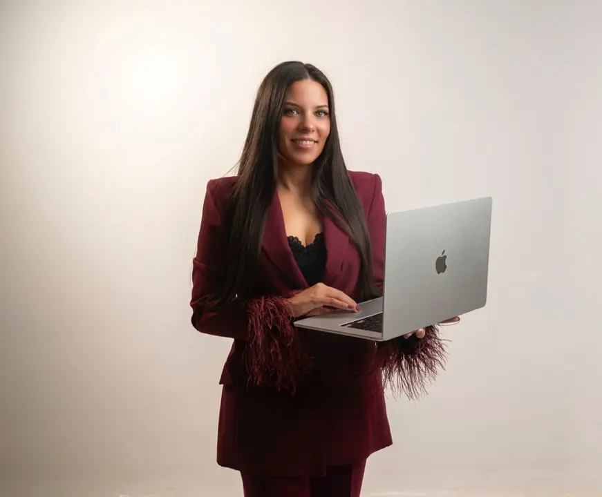 Virginia Honrubia de pie con el ordenador abierto, mostrando su faceta como profesora de cursos de manicura profesional. Formaci&oacute;n especializada en u&ntilde;as con enfoque pr&aacute;ctico, actualizado y orientado al &eacute;xito en el sector de la belleza.