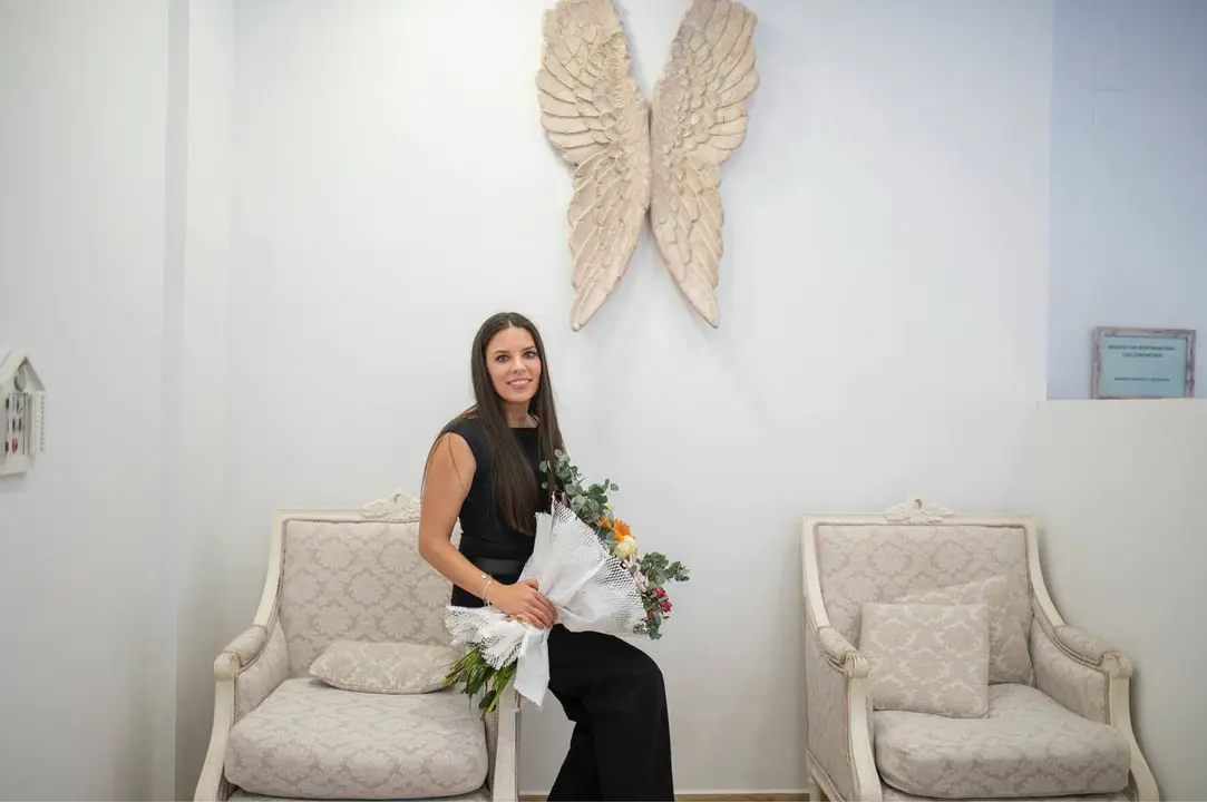 Virginia Honrubia sentada con un ramo de flores recibido por el 8&ordm; aniversario de la apertura de su sal&oacute;n de u&ntilde;as, celebrando a&ntilde;os de dedicaci&oacute;n, profesionalismo y crecimiento en el sector de la manicura y la formaci&oacute;n.
