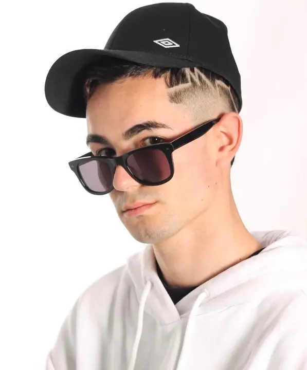 Capirote CPT Music, nombre art&iacute;stico de Felipe Capit&aacute;n Romero, posa con gorra y gafas mirando fijamente a la c&aacute;mara en una imagen que refleja la personalidad y determinaci&oacute;n del joven rapero del Pol&iacute;gono.