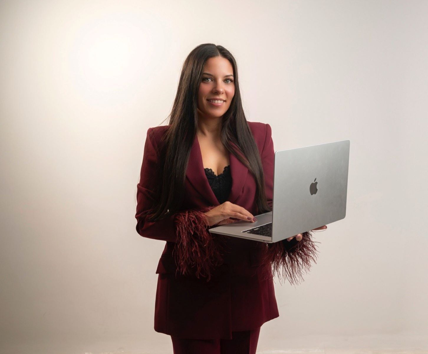 Virginia Honrubia de pie con el ordenador abierto, mostrando su faceta como profesora de cursos de manicura profesional. Formación especializada en uñas con enfoque práctico, actualizado y orientado al éxito en el sector de la belleza.