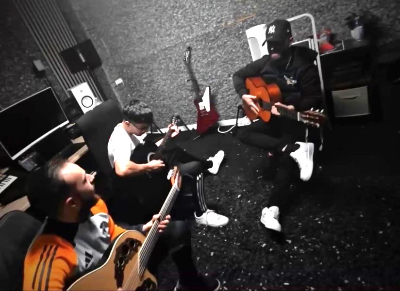 Basi Piculabe, J.G. y Jesús ensayando en un espacio interior, concentrados en la interpretación. Basi Piculabe, J.G. y Jesús aparecen trabajando juntos durante una sesión de práctica musical.